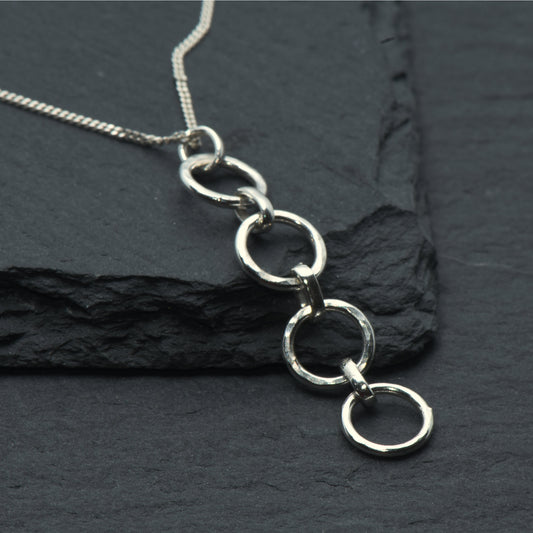 Hammered pendant with 4 circle links on slate