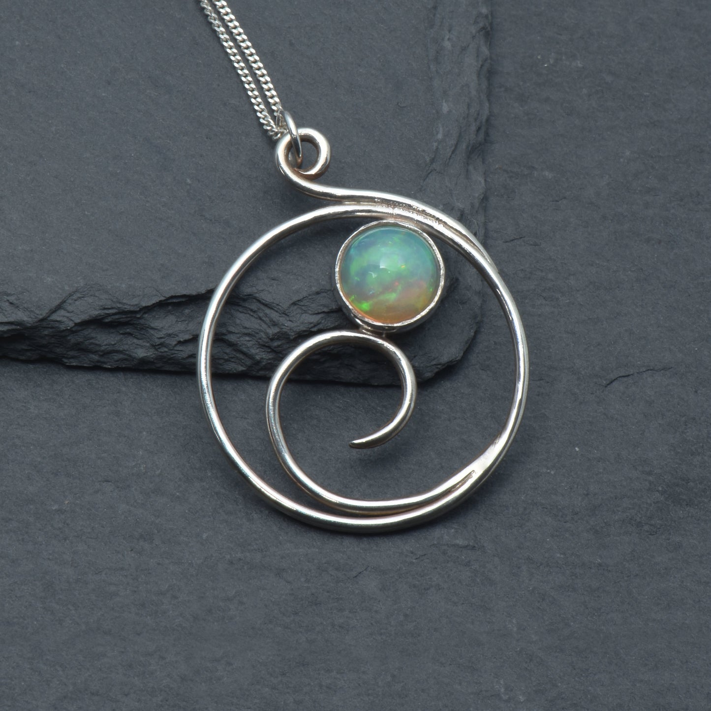 Opal pendant with wave design on a slate background